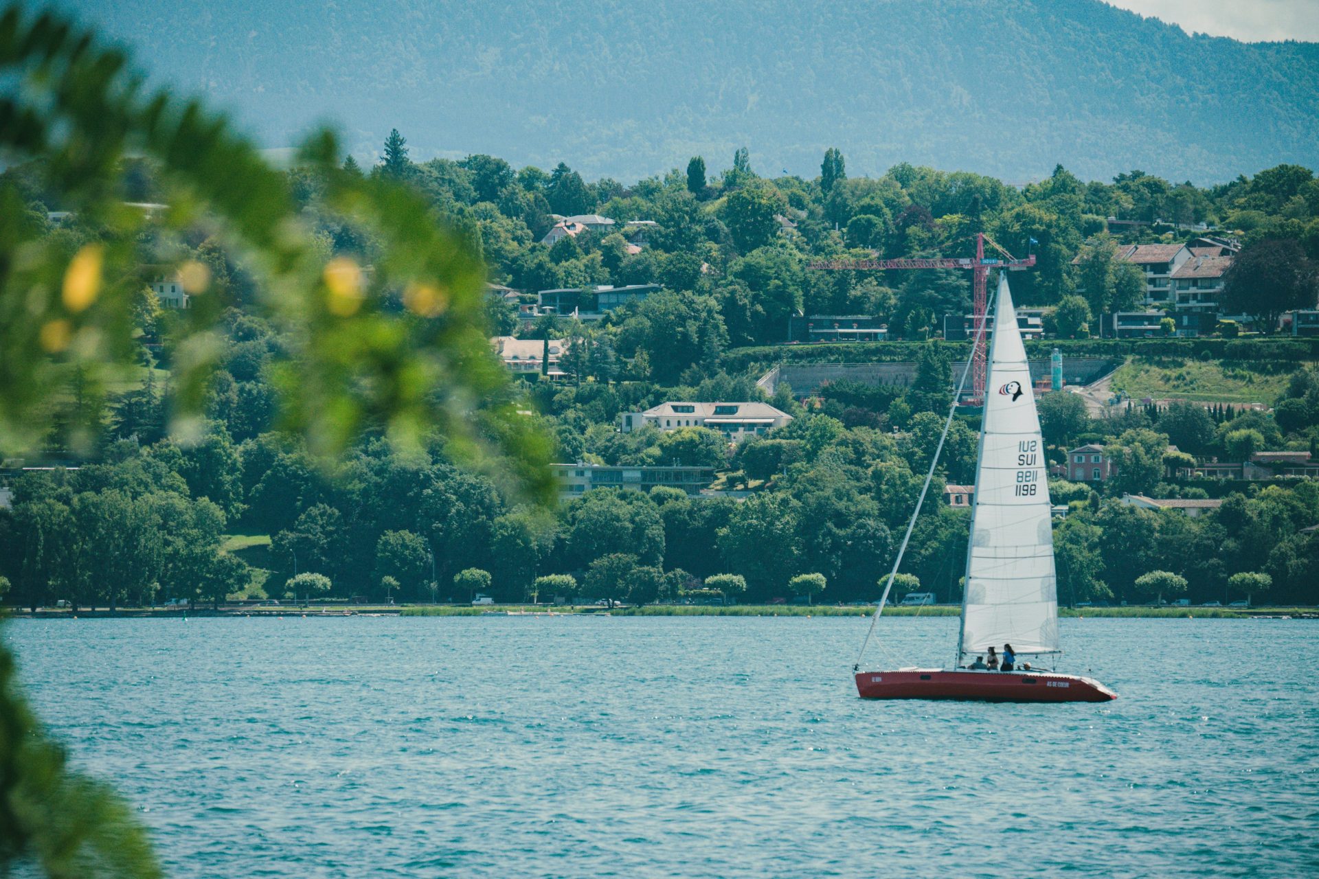 A sailboat on a lake with a mountain in the background